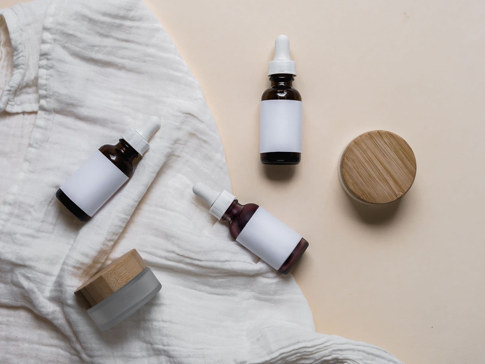 Bottles and jars with blank labels laid on linen