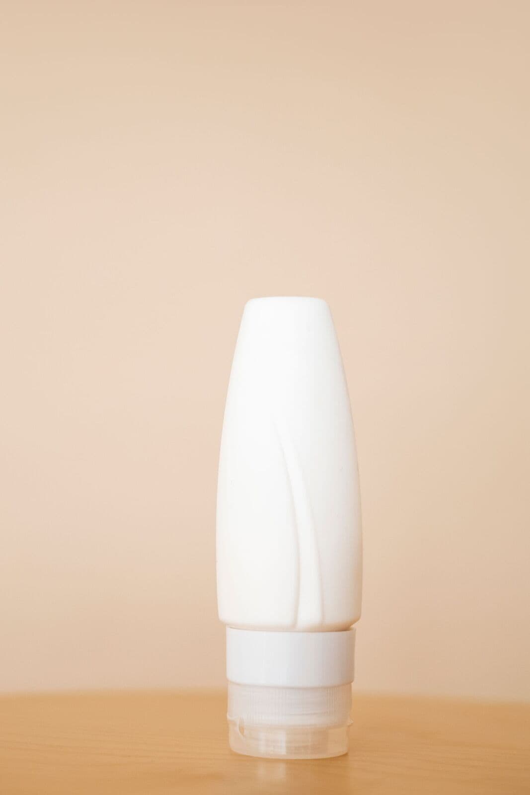 White tube standing on a peach background