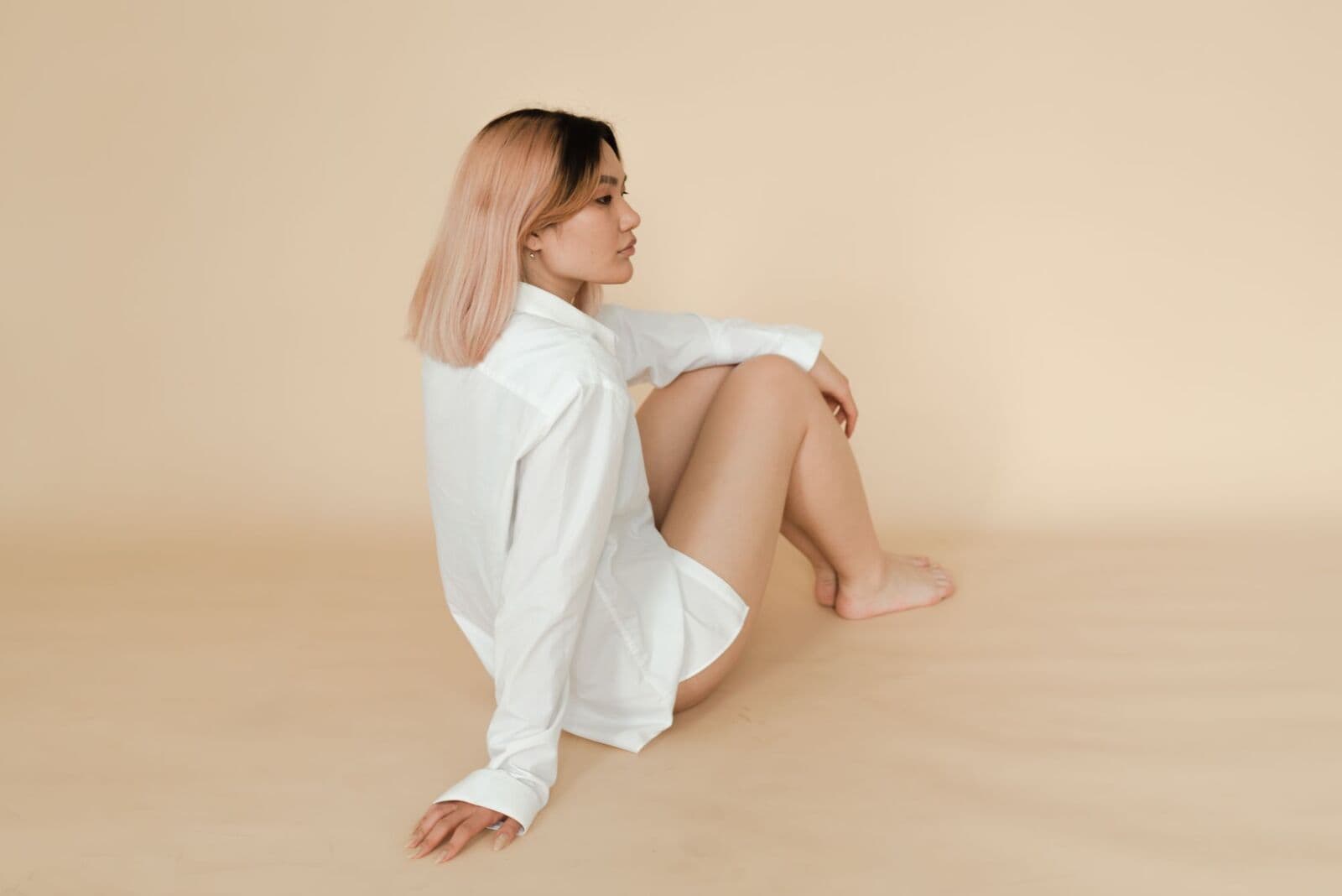 Woman in a white shirt sitting in soft indoor light