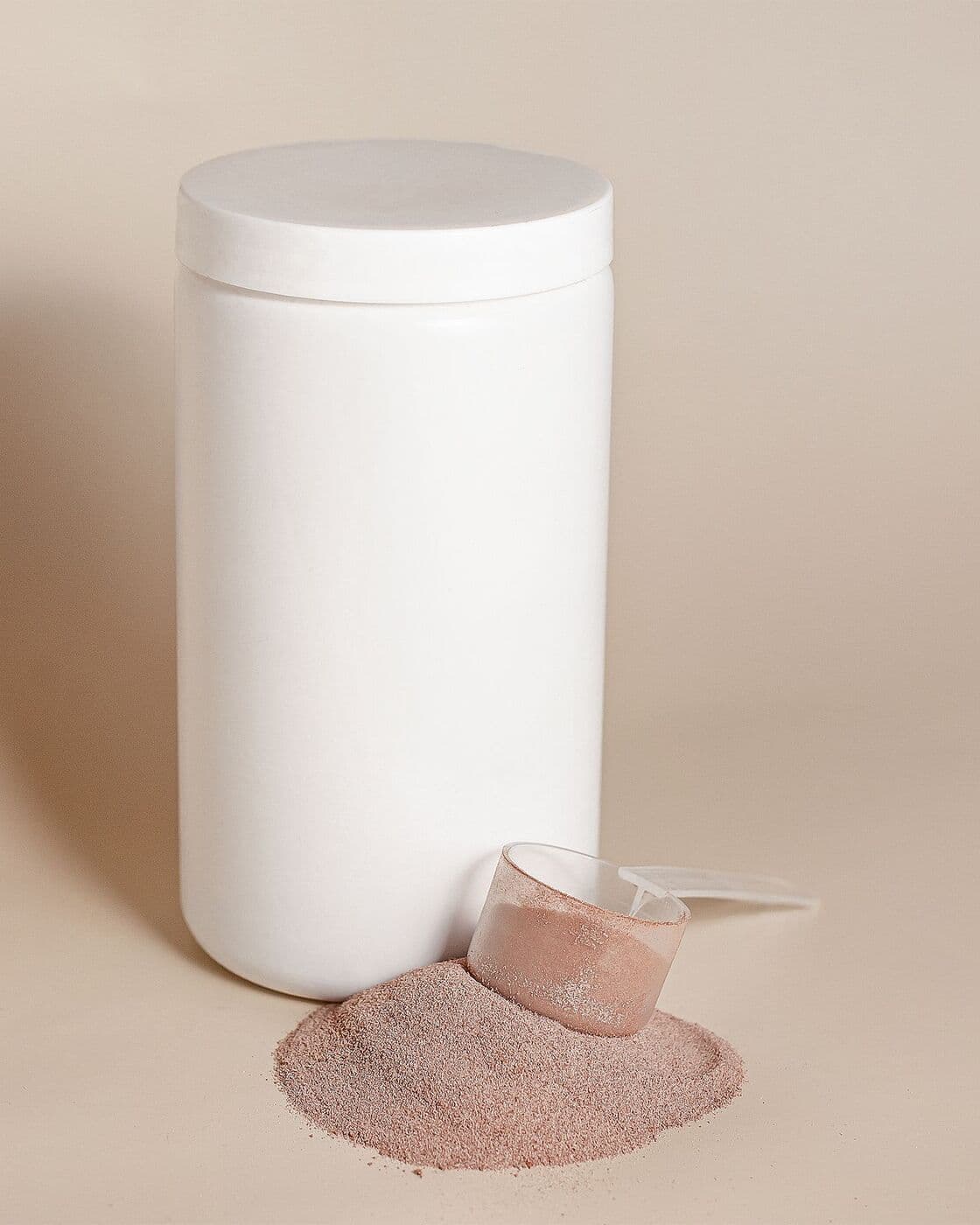 White jar of Enzyme Polish with a scoop of rose powder beside it