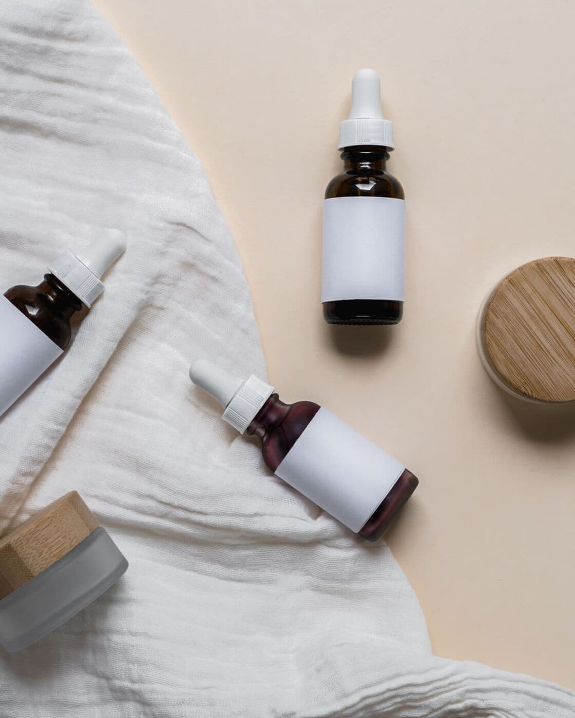 Dropper bottles and jars from the set laid out on linen