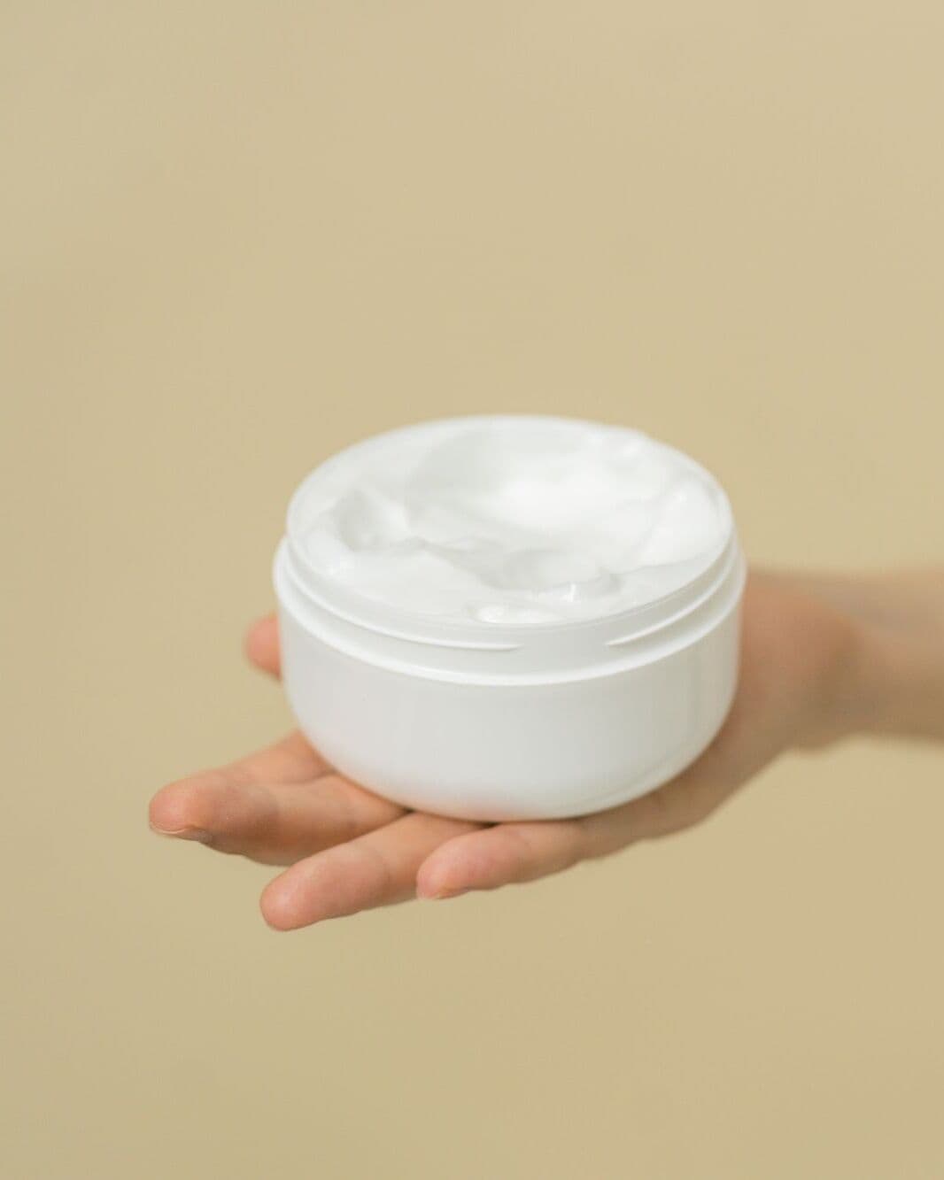 Open jar of Gel Cream held on an outstretched palm
