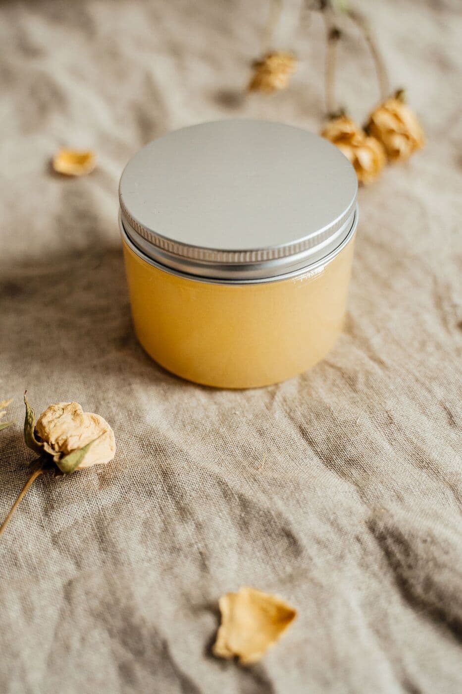 Open jar of Overnight Mask resting on linen