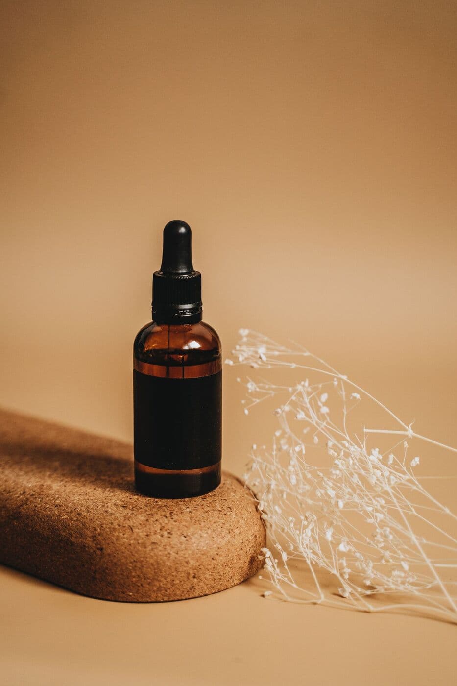 Amber dropper bottle of Vitamin C Serum on a cork block