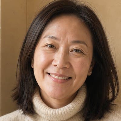 Woman in her forties with shoulder-length dark hair smiling in a cream knit turtleneck
